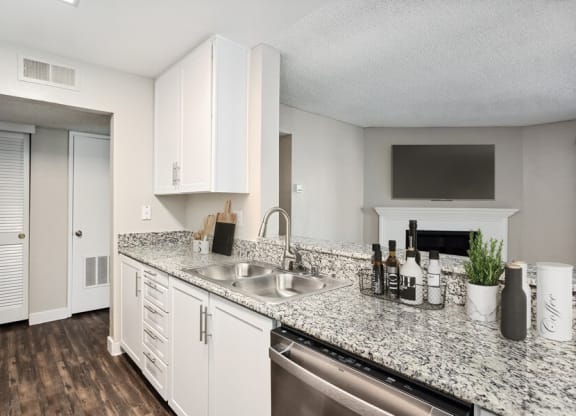 Model kitchen with granite-style counters and white cabinets