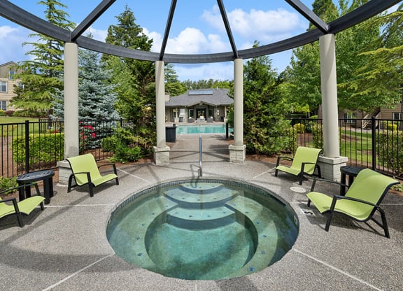 Community Hot Tub and Swimming Pool with Pool Furniture at The Club Apartments located in Hillsboro, OR.