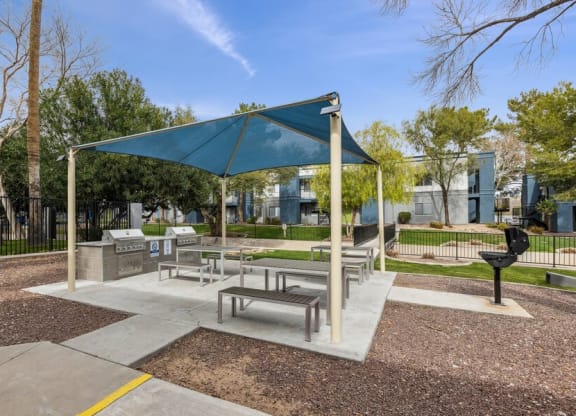 a picnic area with benches and a grill at the preserve at great pond apartments in windsor