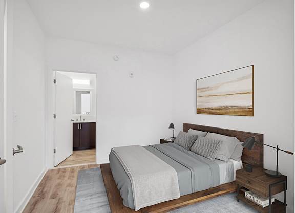 Model Bedroom with Wood-Style Flooring and attached Bathroom at Stella Apartments located in New Carrollton, MD.