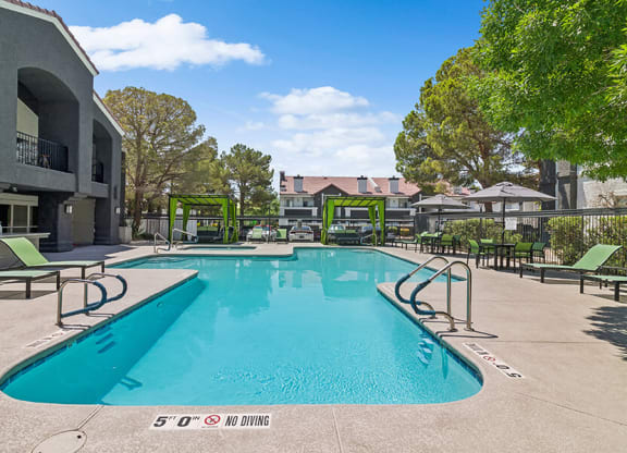 Community Swimming Pool with Pool Furniture at Meadow Ridge Apartments located in Las Vegas, NV.
