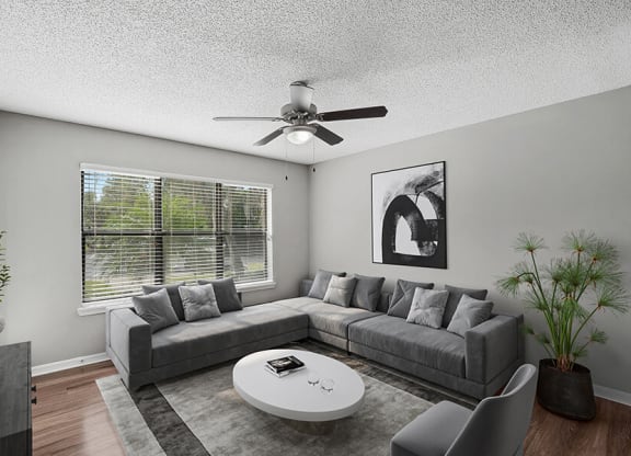 Model Living Room with Wood-Style Flooring and Patio Accessibility at Fountains Lee Vista Apartments in Orlando, FL.