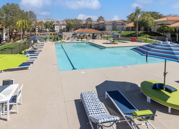 Community Swimming Pool with Pool Furniture at Hilands Apartments in Tucson, AZ.