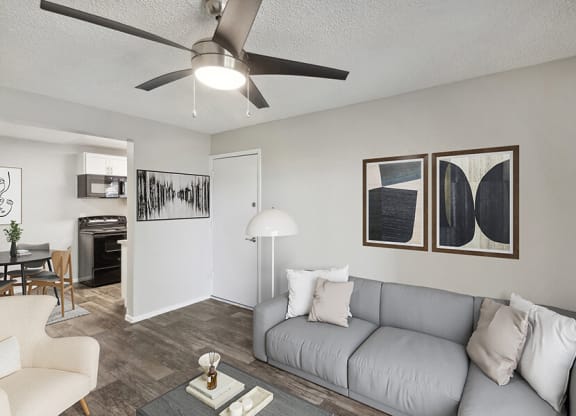 Model Living Room with Wood-Style Flooring and View of Dining/Kitchen Area at Solano Springs Apartments located in Tucson, AZ.