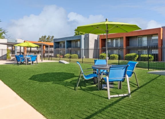 Outdoor Corn Hole Area with Covered Patio Furniture at Indigo Park Apartments in Albuquerque, NM.