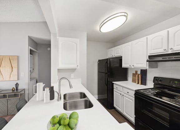 Model Kitchen with White Cabinets and Wood-Style Flooring at Vue at Baymeadows Apartments in Jacksonville, FL.