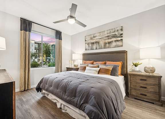 Model Bedroom with Wood-Style Flooring and Window View at Glen 91 Apartments located in Glendale, AZ.