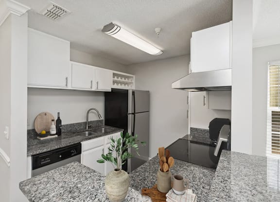 Model Kitchen with White Cabinets and Wood-Style Flooring at Shadow Ridge Apartments in Riverdale, GA.