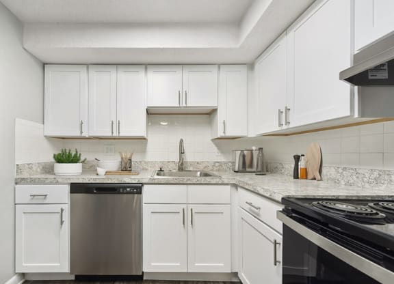 Model Kitchen with White Cabinets and Wood-Style Flooring at Meadows at Marlborough Apartments located in Marlborough, MA.