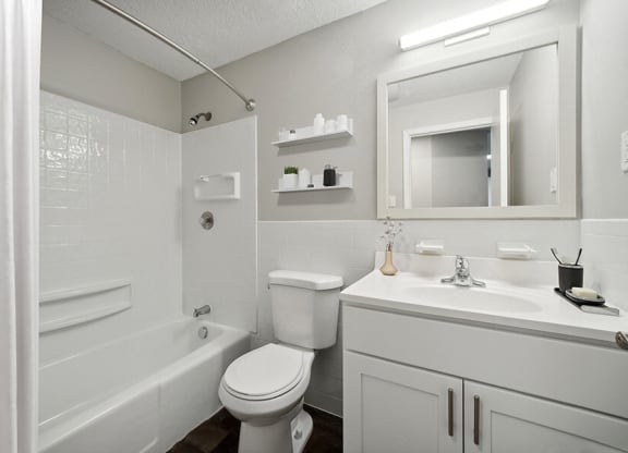 Model Bathroom with White Cabinets, Wood-Style Flooring and Shower/Tub at Middlesex Crossing Apartments in Billerica, MA.