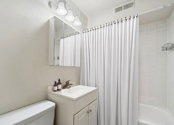 Model Bathroom with White Cabinets and Shower/Tub at Heights Marlborough Apartments in Boston, MA.