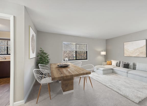 Model Living Room with Carpet and View of Dining Room at Spring Forest Apartments in Raleigh, NC.
