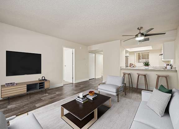 Model Living Room with Wood-Style Flooring and view of Kitchen at Butler Ridge Apartments located in Glendale, AZ.