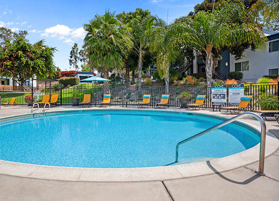 Community Swimming Pool with Pool Furniture at Cove La Mesa Apartments located in La Mesa, CA.