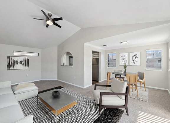 Model Living Room with Carpet and View of Dining Room at Hidden Creek Apartments in Lewisville, TX.