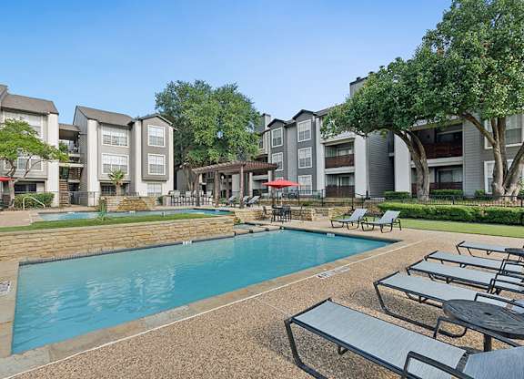 Community Swimming Pool with Pool Furniture at Cobblestone Apartments located in Arlington, TX.