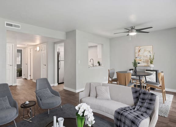 Model Living Room with Wood-Style Flooring and View of Kitchen/Dining Area at Overlook Point Apartments in Salt Lake City, UT.