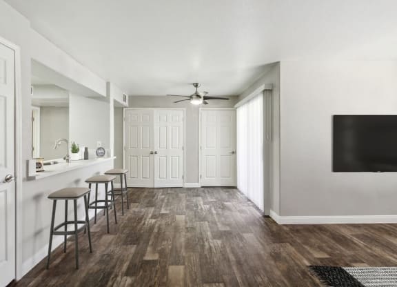 Model living area with a ceiling fan and three stools