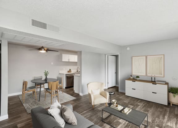 the living room and dining room of an apartment with a table and chairs