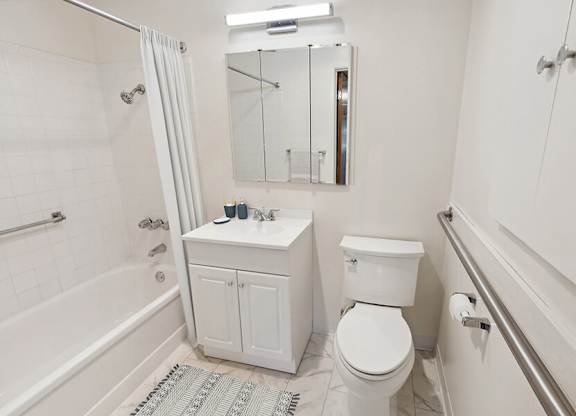 Model Bathroom with White Cabinets, Tile Flooring & Shower/Tub at Walnut Creek Apartments located in Walnut Creek, CA.