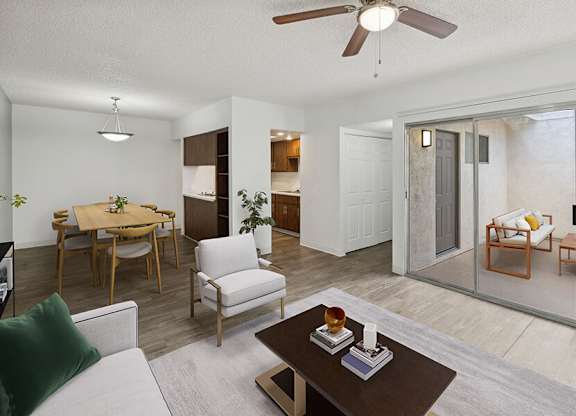 Model Living Room with Wood-Style Flooring, View of Kitchen and Patio Accessibility at Lakeside Casitas Apartments located in Tucson, AZ.