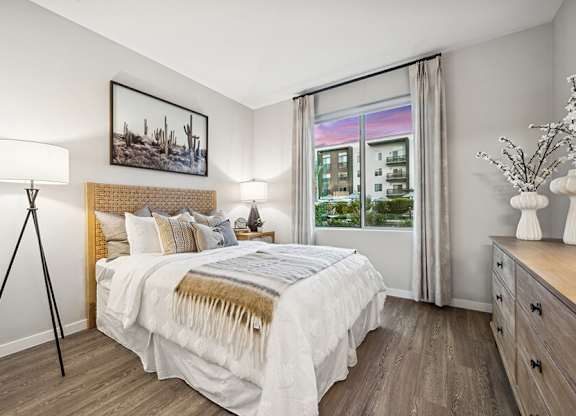 Model Bedroom with Wood-Style Flooring and Window View at Glen 91 Apartments located in Glendale, AZ.