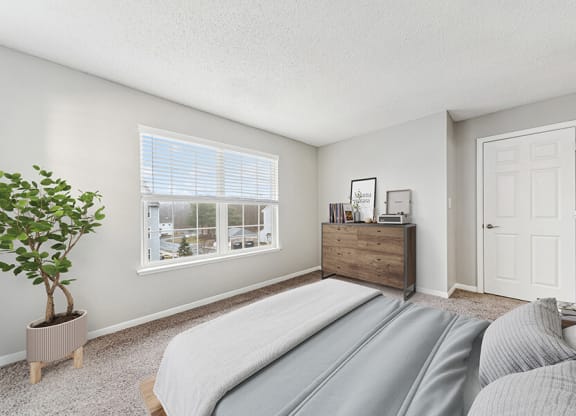 Model Bedroom with Carpet and Window View at Commons at Haynes Farm Apartments in Shrewsbury, MA.