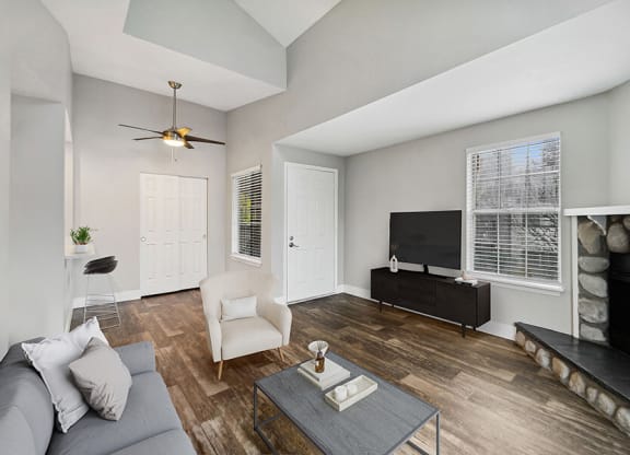 Model Living Room with Wood-Style Flooring, a Fireplace and Patio Accessibility at Central Flats Apartments in Kent, WA.