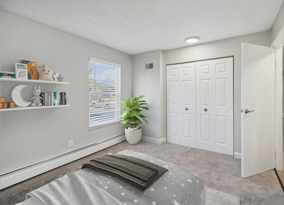 Model Bedroom with Carpet and Closet at Waterfront Apartments in Lakewood, CO.