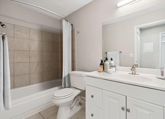 Model Bathroom with White Cabinets and Tile Flooring at Liberty Creek Apartments in Aurora, CO.