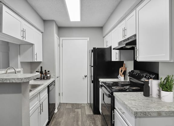 Model Kitchen with White Cabinets and Wood-Style Flooring at Abbington Heights Apartments in Antioch, TN.