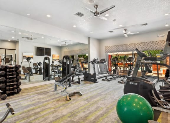 Community Fitness Center with Equipment and Mirrors at Harmony at Surprise Apartments in Surprise, AZ.