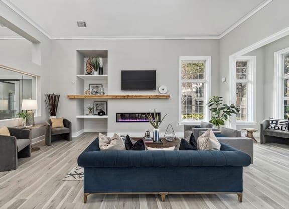 Community Clubhouse with Lounge Furniture and Fireplace at Bridges at Oakbend Apartments in Lewisville, TX.