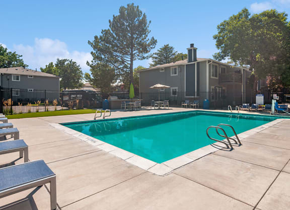 Community Swimming Pool with Pool Furniture at Overlook Apartments located in Salt Lake City, UT.