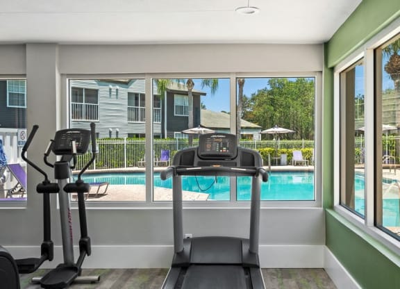 Community Fitness Center with Equipment and Pool View at Waverley Place Apartments in Naples, FL.