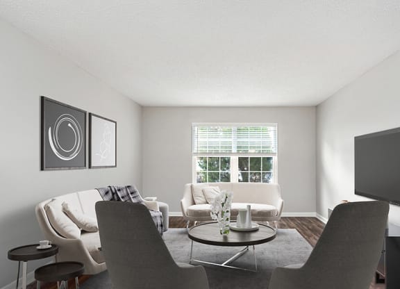 Model Living Room with Wood-Style Flooring and Window View at Commons at Haynes Farm Apartments in Shrewsbury, MA.
