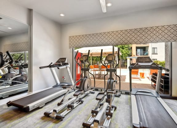 Community Fitness Center with Equipment and Mirrors at Harmony at Surprise Apartments in Surprise, AZ.
