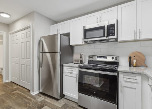 a kitchen with stainless steel appliances and white cabinets