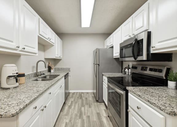 Model kitchen with granite countertops and white cabinets