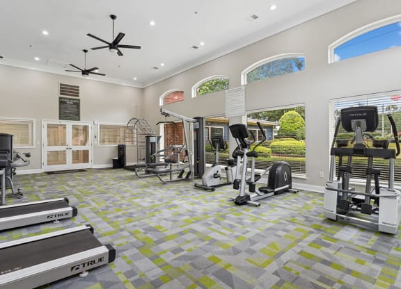 a workout room with treadmills and other exercise equipment