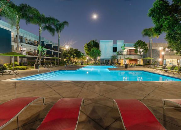 Community Swimming Pool with Pool Furniture at Madison Park Apartments located in Anaheim, CA.