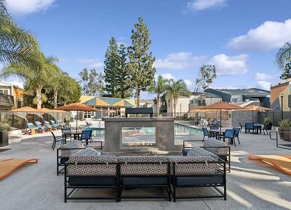 Community Swimming Pool with Pool Furniture at Horizon Apartments located in Santa Ana, CA.