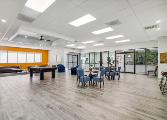 a large room with a pool table and chairs