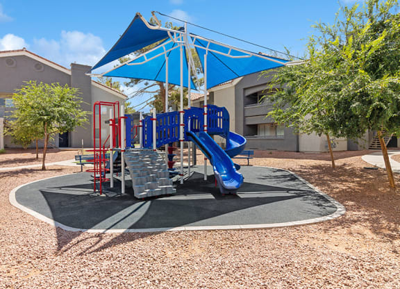 Community Playground with a Slide and Blue Canopy at Verraso Apartments in Las Vegas, NV.