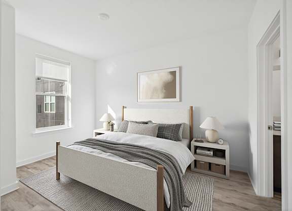 Model Bedroom with Wood-Style Flooring  and attached Bathroom at Stella Apartments located in New Carrollton, MD.