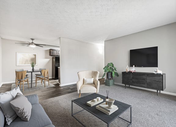 Model Living Room with Carpet and View of Dining Room at Paramont Apartments in Duluth, GA.