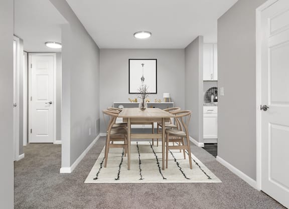 Model Dining Room with Carpet and View of Kitchen at Stone Ends Apartments in Stoughton, MA.