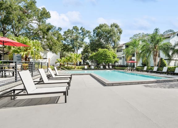 Community Swimming Pool with Pool Furniture at Rosehill Preserve Apartments in Orlando, FL.