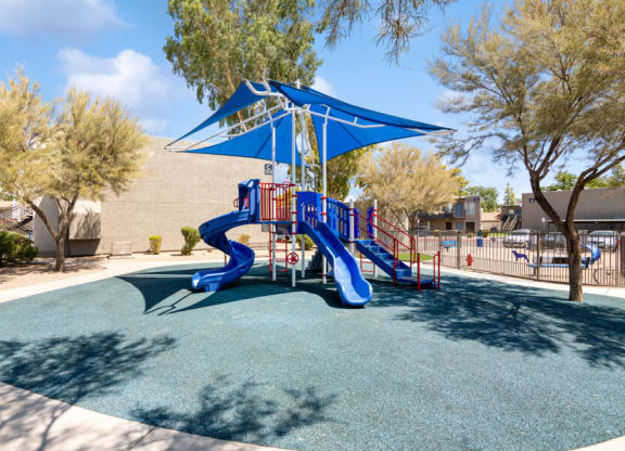 a playground with a blue and red slide at the villas at falling waters townhomes at Villages at Metro Center, Phoenix, Arizona
