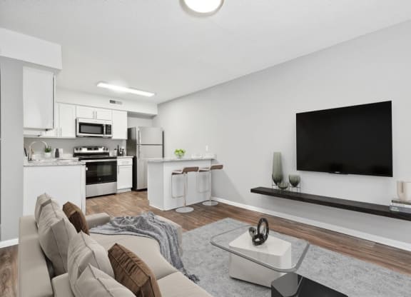 Model living room with view of open kitchen area